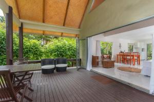 拉罗汤加贝拉海滩简易别墅酒店的开放式甲板配有桌椅和客厅。