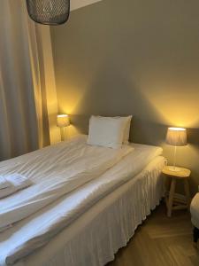 斯塔德我们之家酒店的一间卧室配有一张带两盏灯的床。