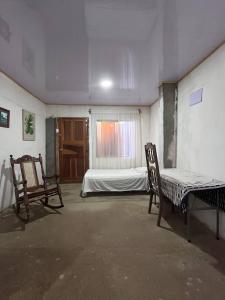 里瓦斯Hostal Brisas del Ometepe的一间设有两把椅子、一张床和窗户的房间
