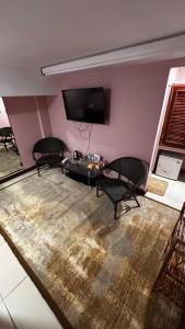 西哈努克China Lounge的客厅配有2把椅子和平面电视