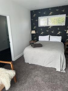但尼丁Guest Suite St Clair Beach的一间卧室设有一张大床和一个窗户。