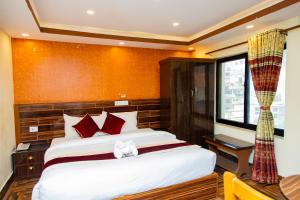加德满都Hotel Everest Regency的一间卧室设有一张大床和一个窗户。