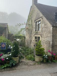 BisleyDove Cottage的一座带门和鲜花的古老石屋