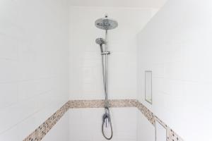 拉罗汤加Bella Beach Lodge的带淋浴的浴室拥有白色的墙壁
