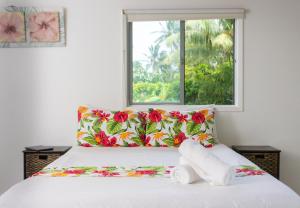 拉罗汤加Bella Beach Lodge的一间卧室配有一张带窗户的床