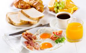 kolkataBRILL A G STAR 500m from International Airport的一张桌子,上面放着两盘早餐食品和一杯橙汁