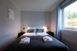 索尔瓦根Lofotlove Apartments - Modern and Comfy Apartments Close To Nature的一间卧室配有一张床,上面有两条毛巾