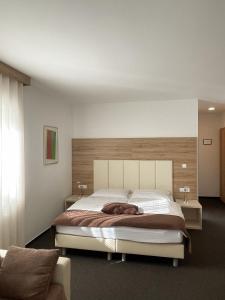克拉尼Hiša Aleš的一间卧室配有一张大床和木制床头板