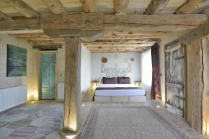 乌奇希萨尔Philosophy Hotel的一间带一张床的卧室,位于带木制天花板的房间内