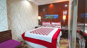 古尔冈SkyCity Hotel Gurgaon的一间卧室配有一张带红色和白色床单的大床