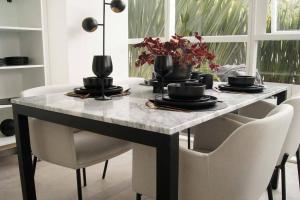 墨西哥城Design Apartment with Amazing Private Terrace的餐桌、白色椅子和大理石台面