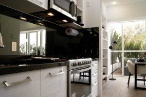 墨西哥城Design Apartment with Amazing Private Terrace的客房内的厨房配有炉灶烤箱