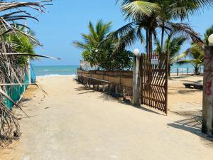 阿鲁甘湾Rainbow Village Cabanas的棕榈树和海洋海滩上的大门