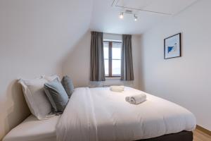 东代恩凯尔克Villa Florentine的卧室配有白色的床和窗户。