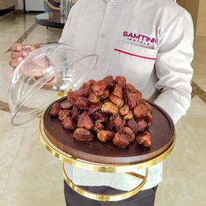 利雅德Samt Inn Hotel的厨师把一盘食物放在桌子上