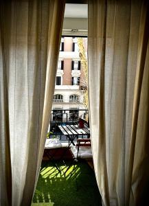 罗马Trastevere House的透过窗户欣赏庭院美景,窗户上设有窗帘