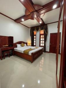 琅勃拉邦PhaiLin Hotel的一间卧室配有一张大床和一张书桌