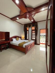 琅勃拉邦PhaiLin Hotel的一间卧室配有一张带吊扇的床