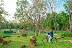北碧Comsaed River Kwai Resort SHA的骑着自行车在公园里的人