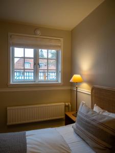 欧登塞Hotel Knudsens Gaard的一间卧室设有一张床和一个窗口