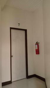 达沃市Sharana Pensionne的一间有消防栓的房间的白色门