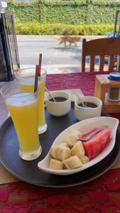 琅勃拉邦PhaiLin Hotel的一张桌子,上面放着一盘食物和两杯饮料