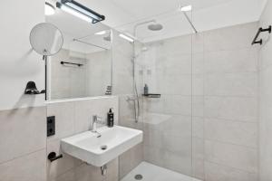 萨尔茨堡limehome Salzburg Sterneckstr.的白色的浴室设有水槽和镜子