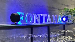 维罗纳Hotel Fontana Verona的 ⁇ 虹灯的标志,在酒架上用眼镜涂上 ⁇ 晕
