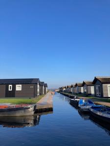 羊角村Waterpark Giethoorn的运河上的一排房屋和船只
