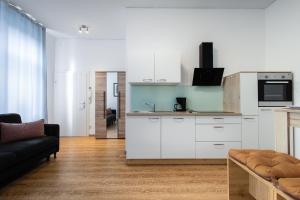 维也纳Siebert16的一间带白色橱柜的厨房和一间客厅