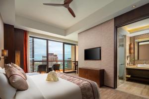 三亚三亚湾红树林度假世界(皇后棕酒店) 的酒店客房,配有床和电视