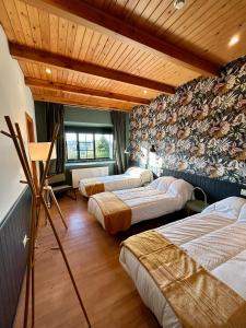 帕拉斯德丽Casa Bolboreta的带四张床的客房,位于带木制天花板的房间内