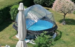 希尼Sweet Home En Gaume的院子里带遮阳伞的帐篷内的热水浴池