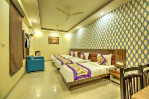 新德里Hotel Smart Plaza Delhi Airport的一间卧室配有两张床和一张蓝色椅子