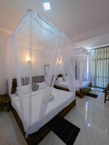 埃拉Kai Kazee Ella的卧室配有带白色蚊帐的天蓬床。