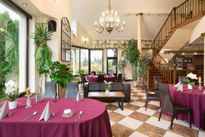 Owińska茉莉酒店 的餐厅设有紫色桌椅和吊灯。