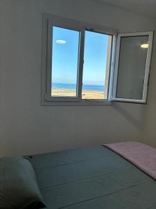 Playa del BurreroCasa Mirtilla的一间卧室设有窗户,享有海滩美景