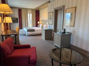 卢加诺德拉帕斯酒店的酒店客房配有床、沙发和桌子。