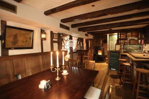 索林根THE CORNISH ARMS Guest House的用餐室配有带蜡烛的木桌