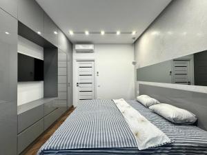 敖德萨Arcadia Luxury Apartments的一间小卧室,配有一张床和电视