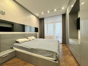敖德萨Arcadia Luxury Apartments的一间卧室设有一张床和一个大窗户