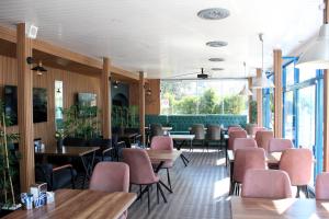 迪迪姆Mavi Restaurant & Bistro的餐厅设有粉红色的椅子和桌子以及窗户。