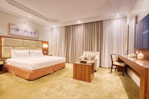 吉达静谧之梦公寓 - 阿尔诺尔分店的配有一张床和一张书桌的酒店客房