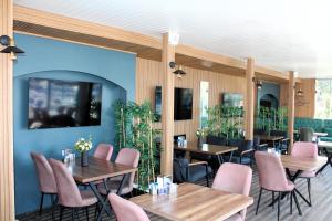 迪迪姆Mavi Restaurant & Bistro的餐厅设有木桌和粉红色的椅子