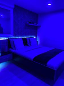 弗朗斯地区特朗布莱Atelier chaleureux 40m2 - Jacuzzi - proche CDG Parc des expo的蓝色卧室配有一张蓝色灯光大床
