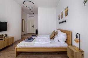 布达佩斯AK7 Boutique Suites的一间卧室配有带白色床单和枕头的床。