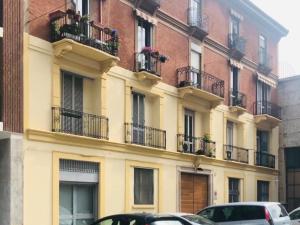 米兰La Casa sul Ballatoio - Isola Milano的带阳台的建筑,门前有车辆停放
