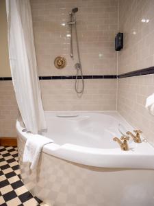 奇切斯特维斯特瑞酒店的带淋浴的浴室内的白色浴缸