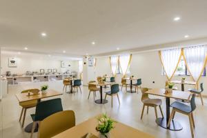 昆明City Comfort Inn Kunming Dashuying Yejin Hospital Wangdaqiao的用餐室设有桌椅和窗户。