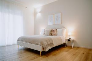 维罗纳Alatea Apartments Valverde的卧室配有一张带白色墙壁和木地板的大床
